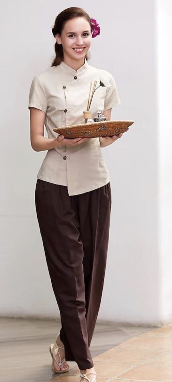 Beige spa uniform with asymmetrical button front, mandarin collar, and brown straight-fit pants
