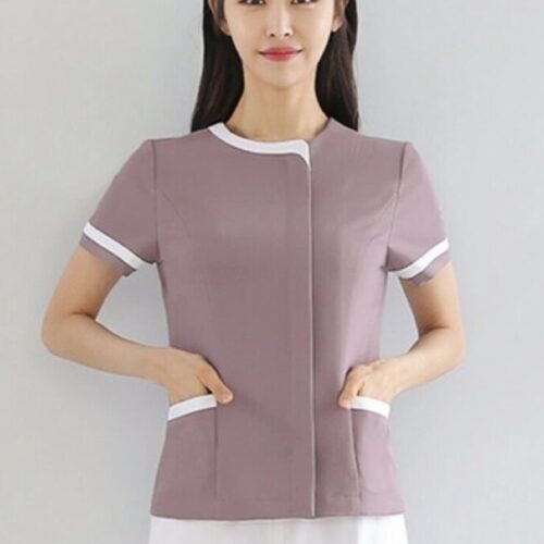 Dusty pink spa uniform with white piping, round neckline, and front pocket detailing